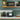 Dualit Classic 2-slice toaster in evergreen in a green kitchen with jars of tea and a wooden shelf