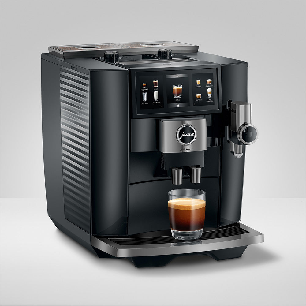 Jura J10 twin in Diamond Black, on a gray background, angled to the right, with a coffee