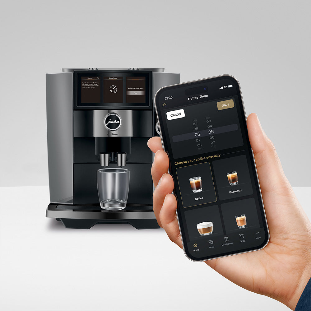 Jura J10 twin in Diamond Onyx, on a gray background, with the J.O.E. app on a phone