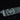 Close-up of a black WÜSTHOF PERFORMER blade with its large trident logo and drops of water