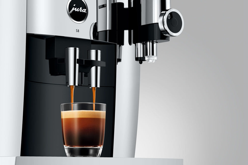 Jura S8 in Chrome, coffee pouring from the dual spout into a glass