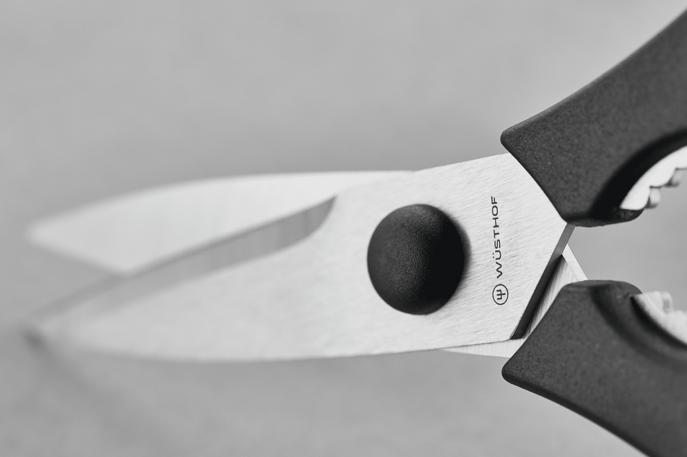 Close-up of the blades, pivot and WÜSTHOF logo of black-handled kitchen shears