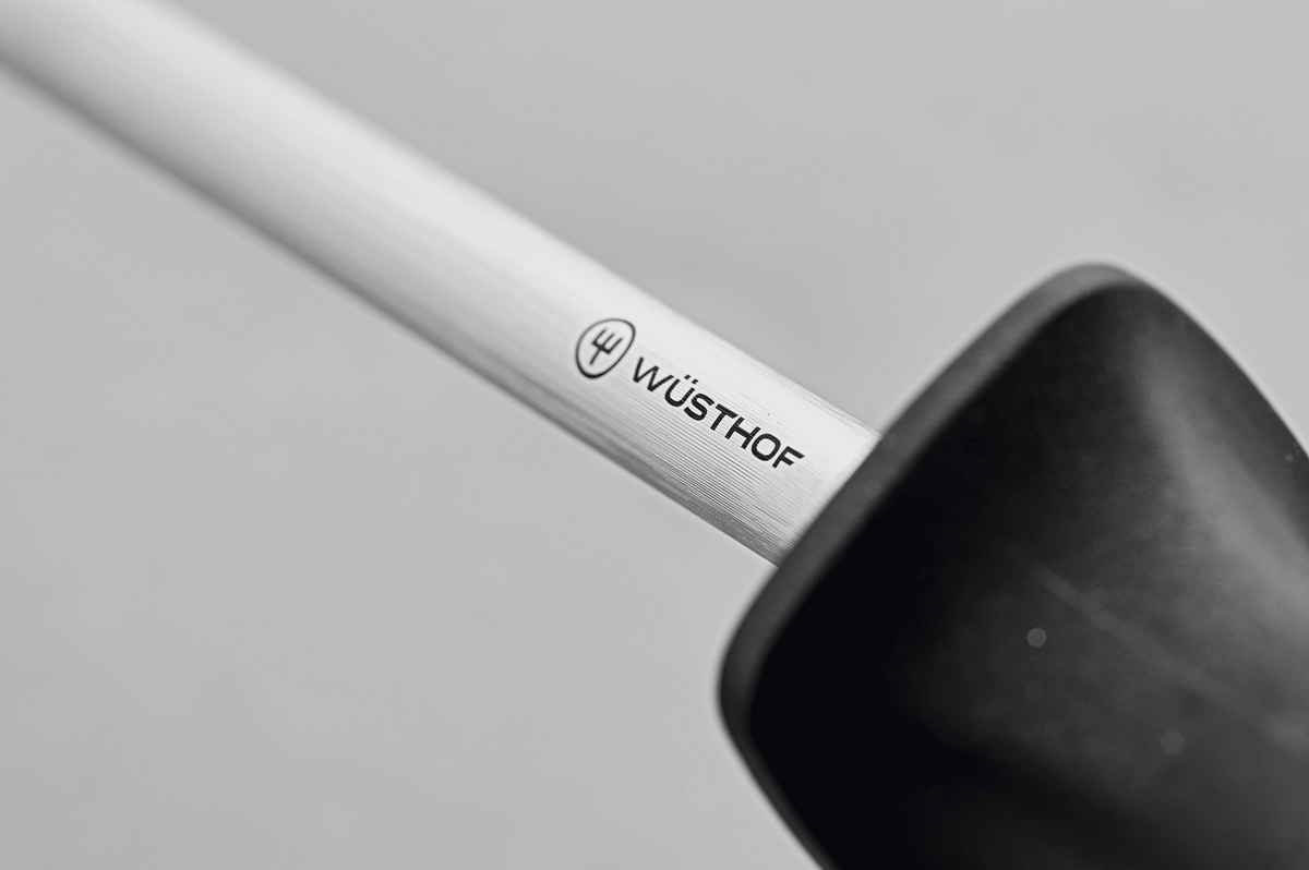 Close-up of the WÜSTHOF logo on the steel where it meets the black handle of the 10" Honing Steel with Loop