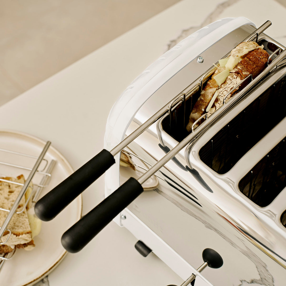 Dualit sandwich cages with a toasted sandwich in a Dualit Classic 4-slice toaster in white, seen from above