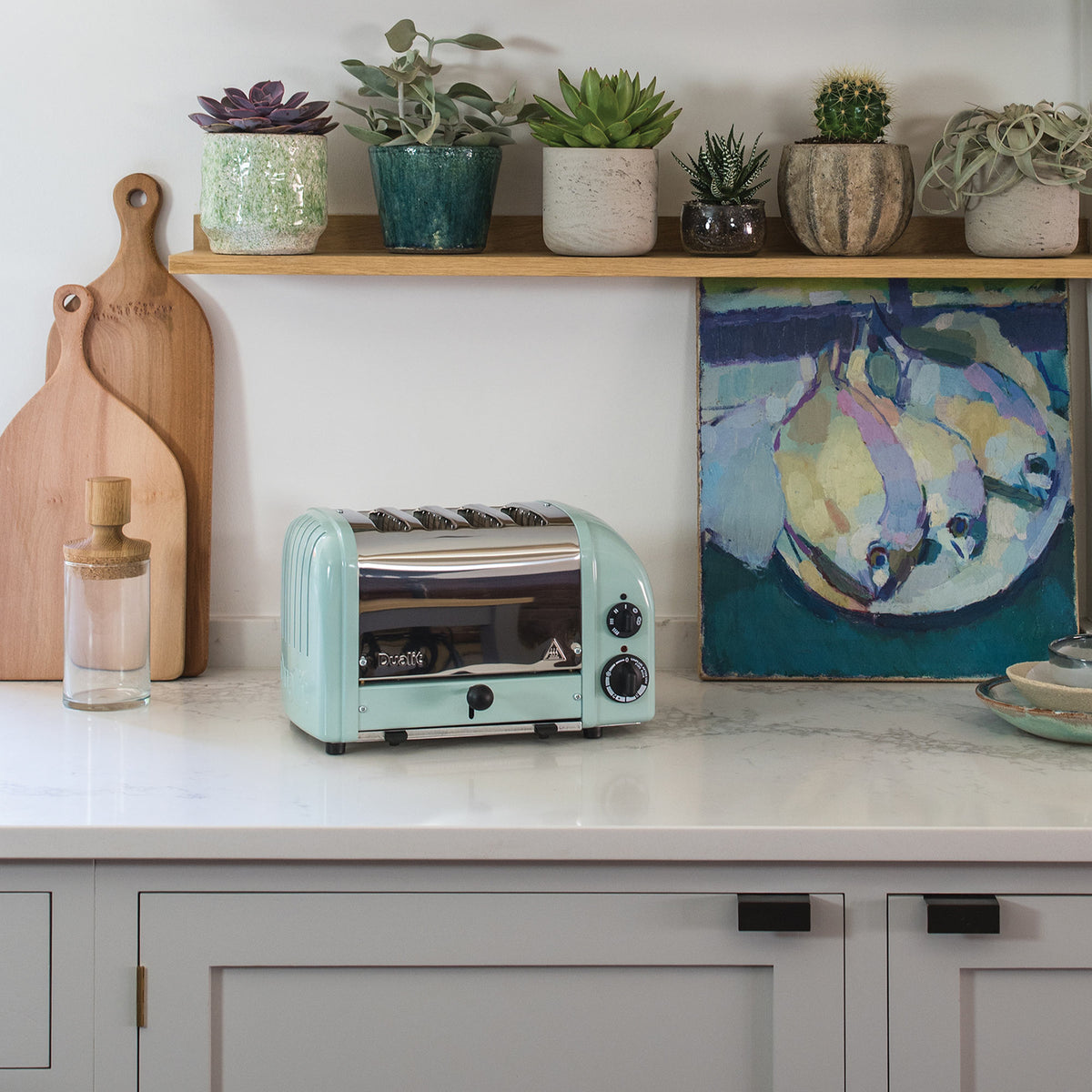 Dualit Classic 4-slice toaster in eucalyptus in a white kitchen with succulents and a painting