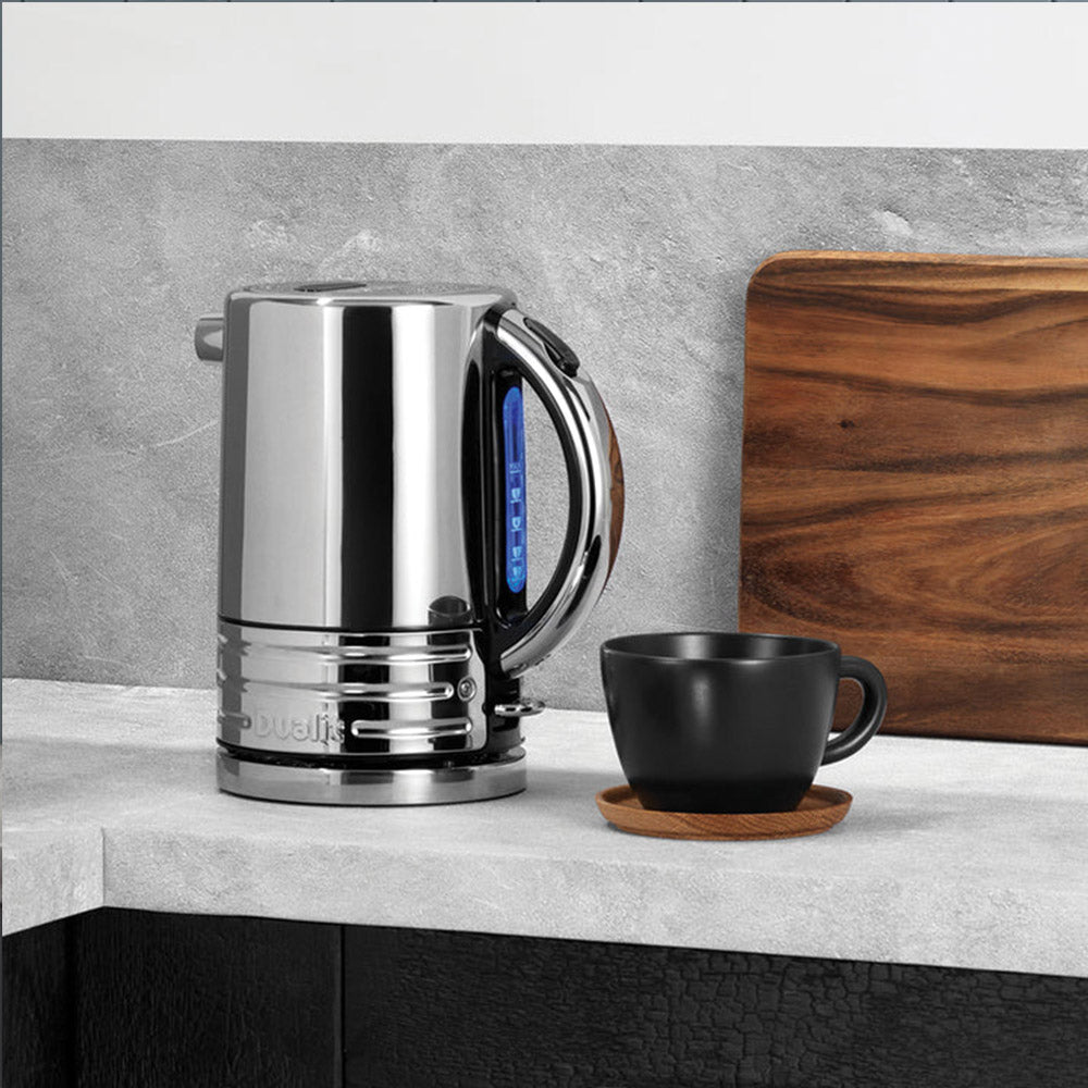 Dualit Design Series kettle on a grey stone counter with a black cup and a wooden board