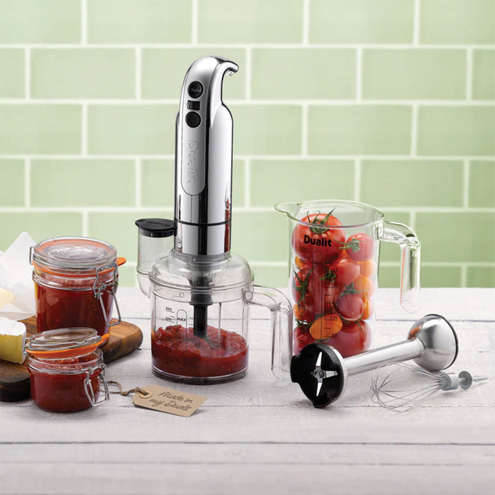 Dualit hand blender with the chopper, a jug of tomatoes and jars of preserve against green tiles