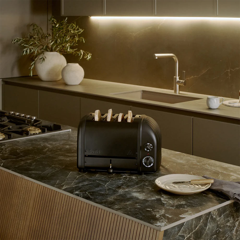 Dualit Classic 4-slice toaster in Stealth with toast on a dark stone kitchen island