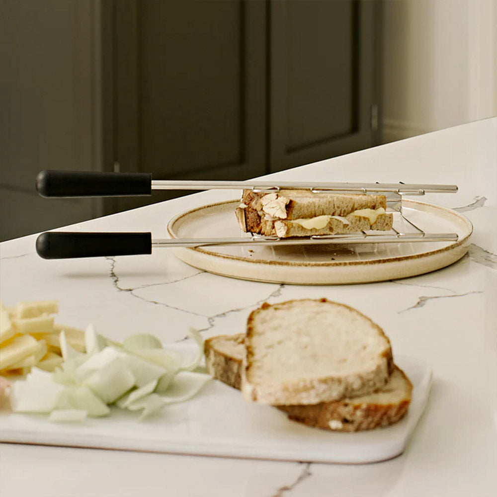 Dualit sandwich cages on a plate with a toasted sandwich beside sliced bread