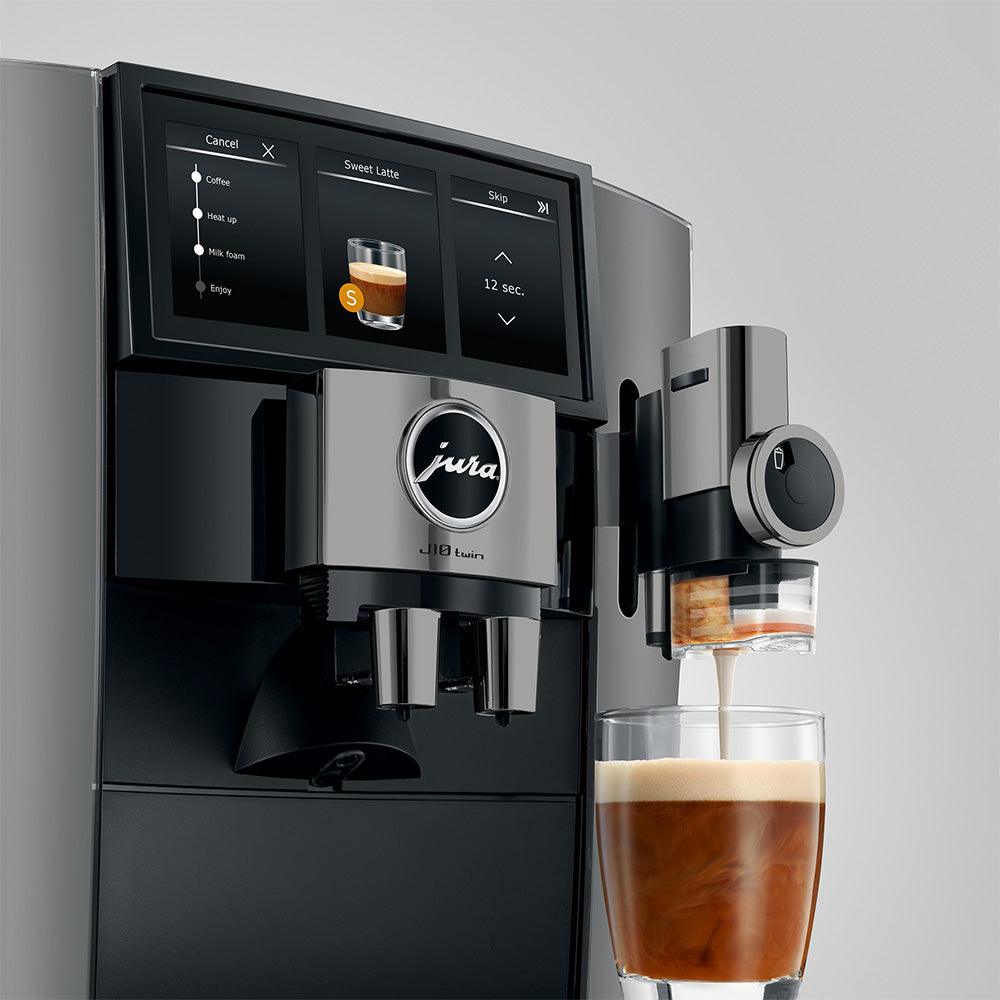 Jura J10 twin in Diamond Onyx, close-up on a gray background, Panorama Coffee Panel and a coffee being prepared