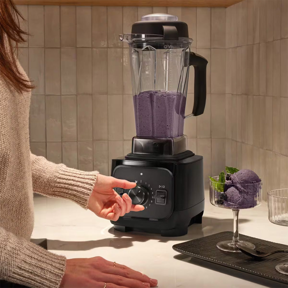Hand turning the speed dial of a Vitamix VX1 Blender in Black