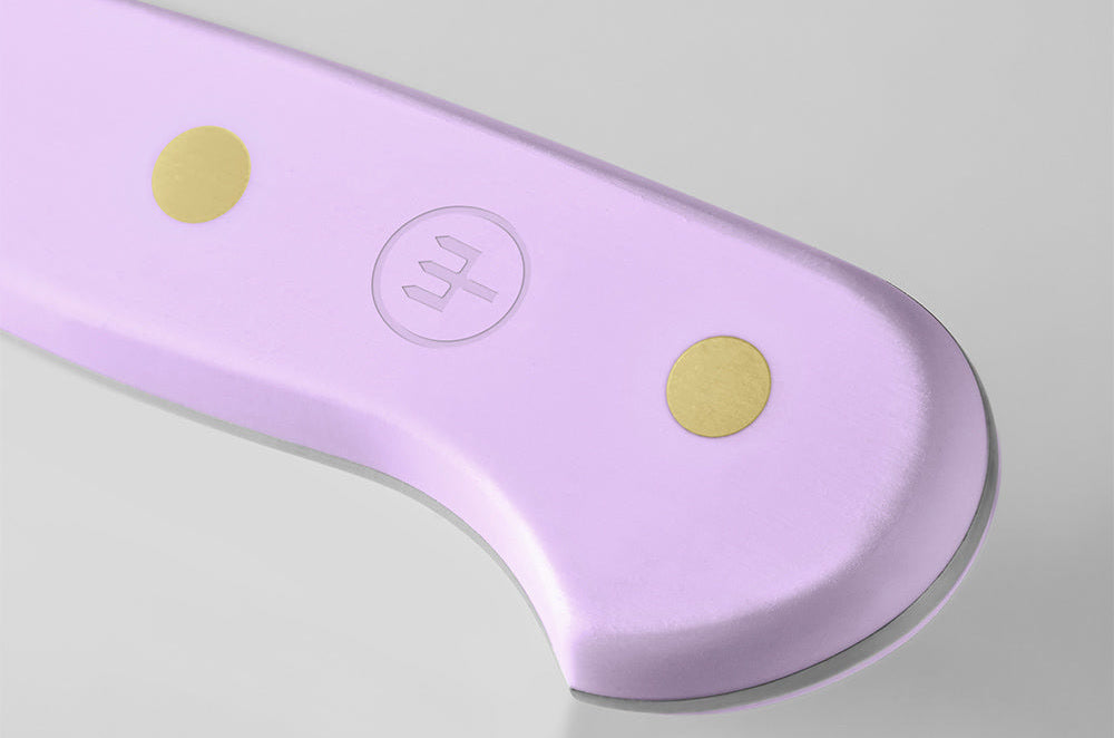 Close-up of the end of the Purple Yam handle of a WÜSTHOF CLASSIC knife, with its rivets and trident logo