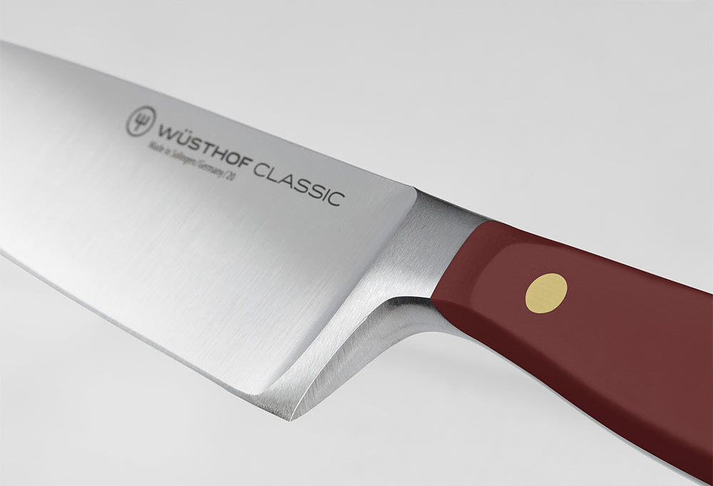 Close-up of the bolster where the blade of a WÜSTHOF CLASSIC knife meets the Tasty Sumac handle