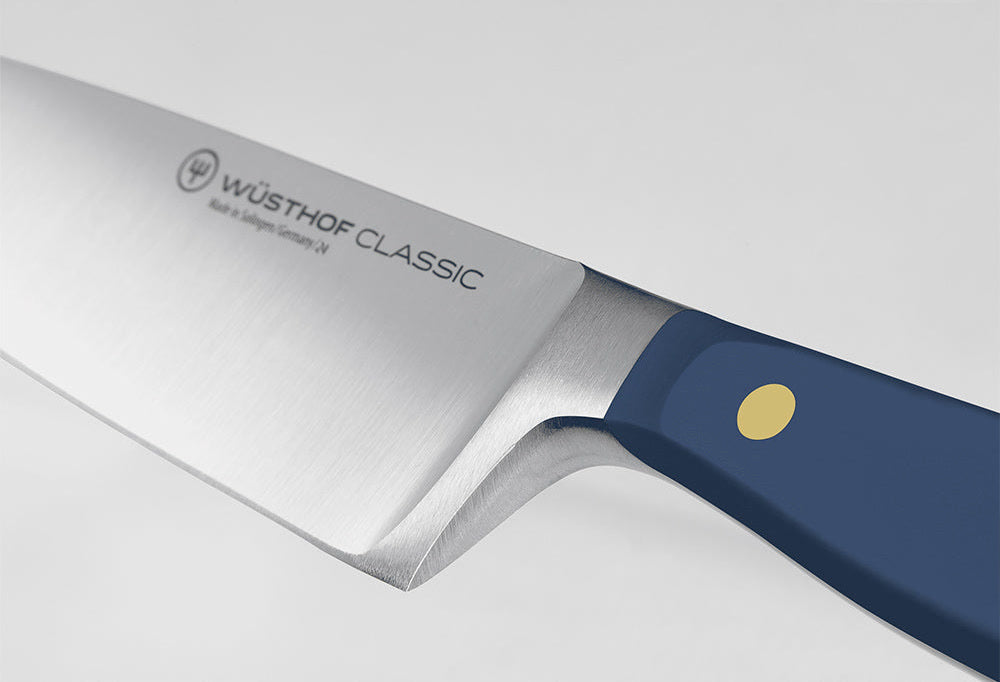 Close-up of the bolster where the blade of a WÜSTHOF CLASSIC knife meets the Wild Blueberry handle