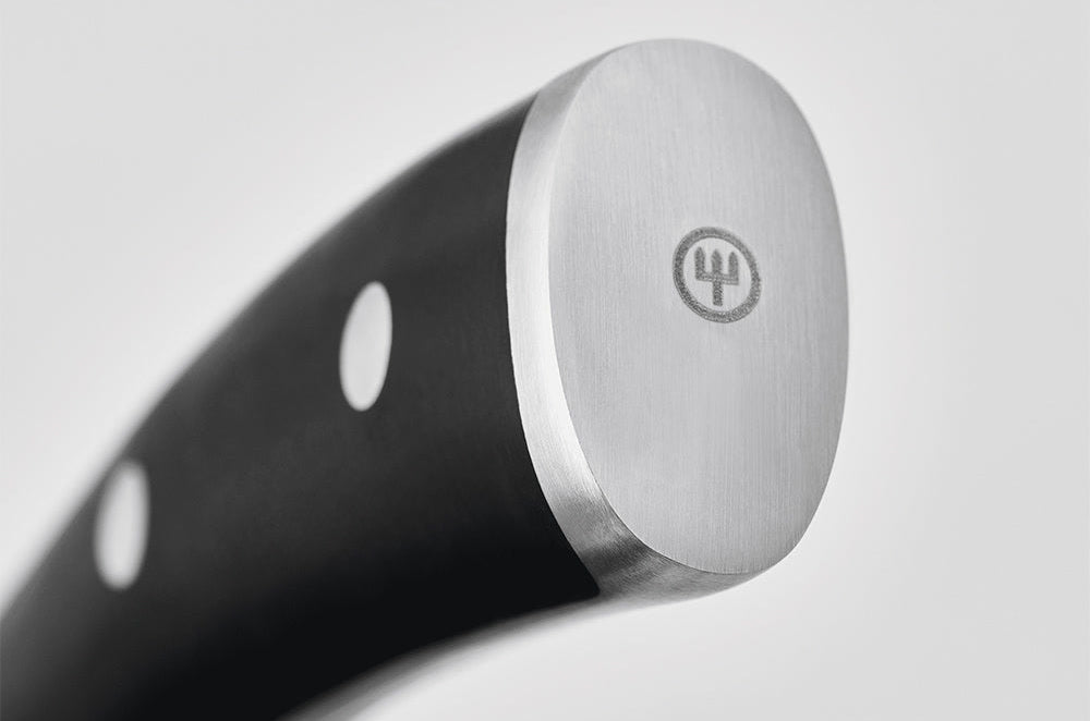 Close-up of the end cap with trident logo on the black handle of a WÜSTHOF CLASSIC IKON knife