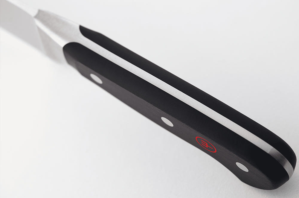 Close-up of the black handle of a WÜSTHOF CLASSIC knife from the spine side, showing the tang
