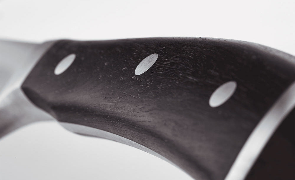 Close-up of the dark brown handle of a WÜSTHOF IKON knife, with its rivets