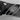 Close-up of the double-serrated edge and trident logo on the black blade of a WÜSTHOF PERFORMER bread knife