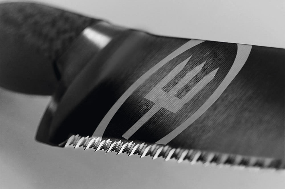 Close-up of the double-serrated edge and trident logo on the black blade of a WÜSTHOF PERFORMER bread knife