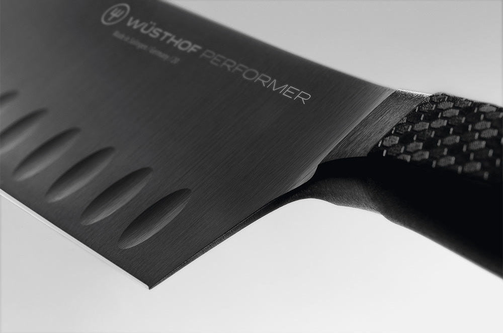 Close-up of where the hollow edge blade of the WÜSTHOF PERFORMER 7" Hollow Edge Rotoku meets the handle