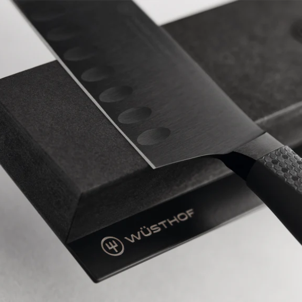 Close-up of a PERFORMER hollow edge knife held on the WÜSTHOF PERFORMER Magnetic Holder