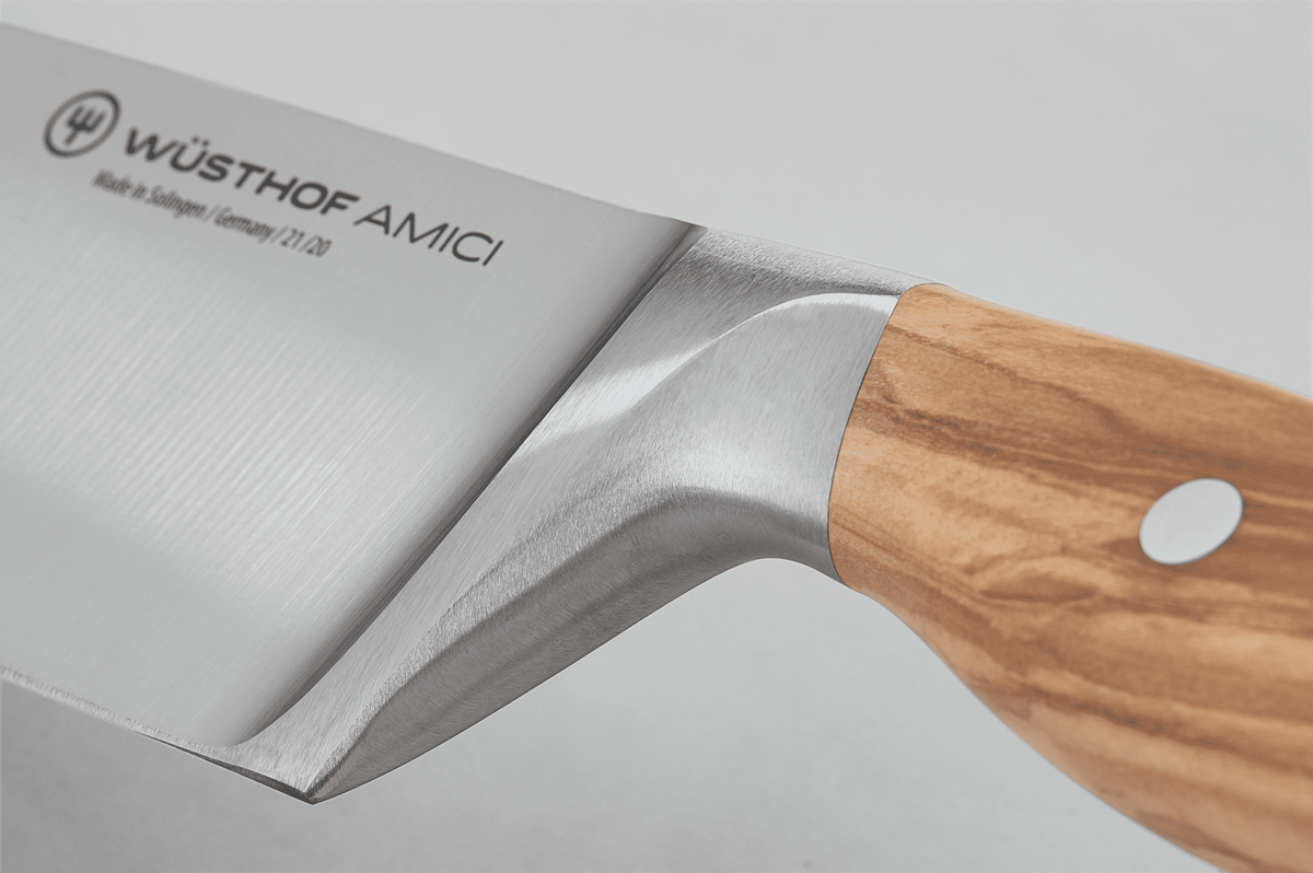 Close-up of the bolster where the blade of the WÜSTHOF AMICI 8" Chef's Knife meets the wooden handle