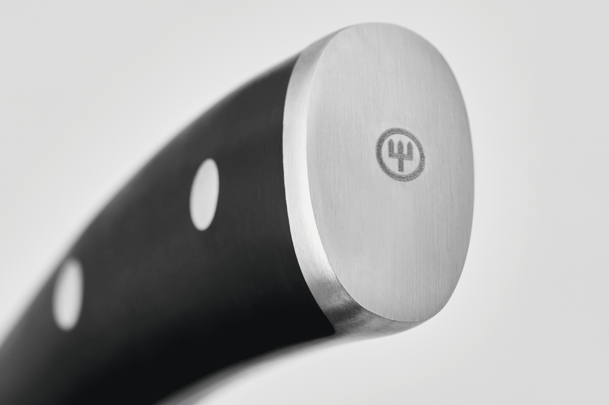 Close-up of the end cap with trident logo on the black handle of a WÜSTHOF CLASSIC IKON knife