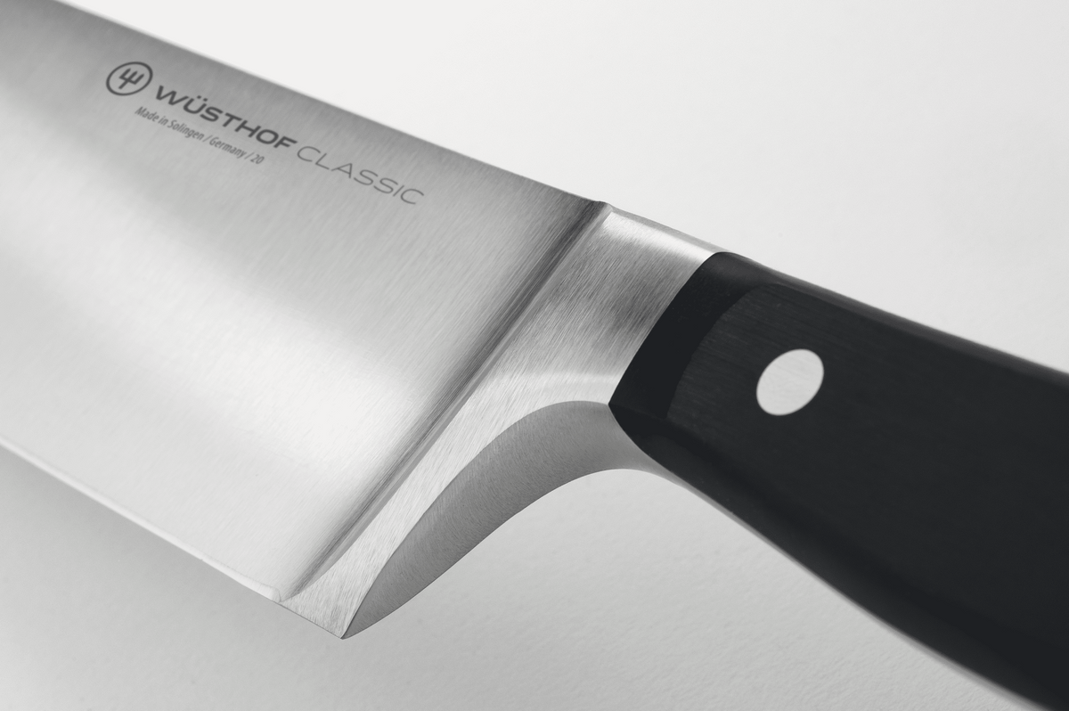 Close-up of the bolster where the blade of a WÜSTHOF CLASSIC knife meets the black handle