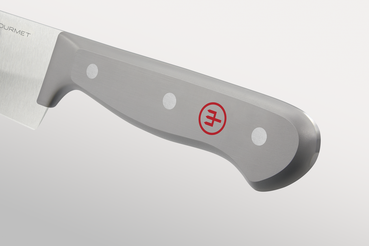 Close-up of the grey handle of a WÜSTHOF GOURMET knife, with its rivets and red trident logo